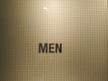 Creative men toilet sign with word means restroom on abstract wall Royalty Free Stock Photo