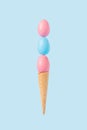 Creative minimal composition made with colorful pastel eggs balancing on ice cream cone. Trendy Summer or Easter concept