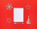 Creative minimal Xmas mockup on red background with wooden decorations and white notepad with copy space Royalty Free Stock Photo