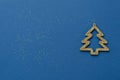 Creative minimalist Christmas or new year card. Gold Christmas tree on a blue background with sequins. Copy space for text