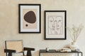 Creative minimalistic composition of stylish modern living room interior with two mock up poster frames, black geometric commode.