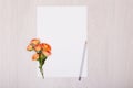 Creative mock up with a card and orang rose. Empty sheet of paper.