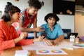 Creative multiracial design professionals discussing over charts and smart phone in office Royalty Free Stock Photo