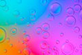 Creative neon background with drops. Glowing abstract backdrop with vibrant gradients on bubbles. Multicolor overflowing