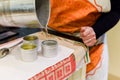 Creative occupation of candle making showing the pouring of liquid wax into jars Royalty Free Stock Photo