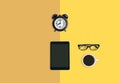 Creative office working space concept, Alarm clock, Coffee, eyeglasses and tablet yellow background