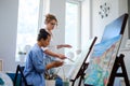 Creative painter and her protege working in a studio Royalty Free Stock Photo