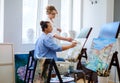 Creative painter and her protege working in a studio Royalty Free Stock Photo