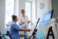 Creative painter and her protege working in a studio Royalty Free Stock Photo