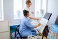 Creative painter and her protege working in a studio Royalty Free Stock Photo