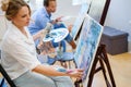 Creative painter and her protege working in a studio Royalty Free Stock Photo