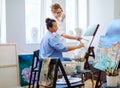 Creative painter and her protege working in a studio Royalty Free Stock Photo