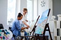 Creative painter and her protege working in a studio Royalty Free Stock Photo