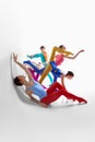 Creative performance. Young girls, ballet dancer in bright tights and bodysuits dancing against grey studio background