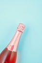 Creative photo of rose champagne bottle on blue background Royalty Free Stock Photo