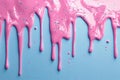 Creative pink paint drips over a textured blue surface background Royalty Free Stock Photo