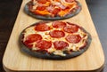 Creative pizza on black dough, two pieces on the board. Royalty Free Stock Photo