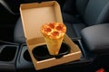 Unique pizza cone in takeout box on car center console during a road trip Royalty Free Stock Photo