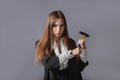 Creative portrait of a businesswoman with a hammer in her hands. Gray background Royalty Free Stock Photo