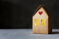 Creative present box, cardboard house with lights inside and red heart as symbol of love