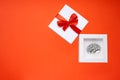 Creative present in form of a small copy of a human brain lying inside a white gift box with a red ribbon and bow on the cover.