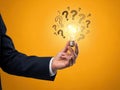 Creative problem solving with bright idea and question marks around light bulb Royalty Free Stock Photo