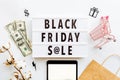 Creative promotion composition Black friday sale text on lightbox on white background, next grocery trolley, credit card, cash Royalty Free Stock Photo