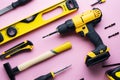 Creative provocation: a flat layout of yellow hand tools on a pink background. Royalty Free Stock Photo