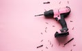 Creative provocation: a pink screwdriver on a pink background and small pink screws.