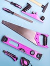 Creative provocation: a set of pink hand tools for construction and repair on a blue background. Royalty Free Stock Photo