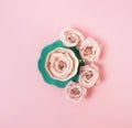 Creative romantic layout gift made of green coffee cup with pink roses on pink background.