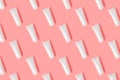 Creative seamless pattern from plastic cream tube on pastel pink background.