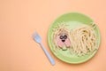 Creative serving for kids. Plate with cute dog made of tasty pasta, sausage and cucumber on pale orange table, flat lay. Space for