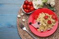 Creative serving for kids. Plate with cute hedgehog made of delicious pasta, sausages and tomatoes on light blue wooden table,