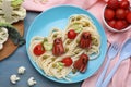 Creative serving for kids. Plate with cute octopuses made of sausages, pasta and vegetables on light blue wooden table, flat lay Royalty Free Stock Photo