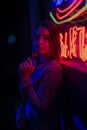 Creative sexual portrait of a girl in neon lighting with glasses