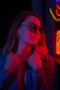 Creative sexual portrait of a girl in neon lighting with glasses