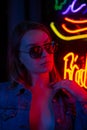 Creative sexual portrait of a girl in neon lighting with glasses