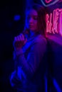 Creative sexual portrait of a girl in neon lighting with glasses, night party, dancing, game business, striptease