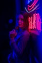 Creative sexual portrait of a girl in neon lighting with glasses, night party, dancing, game business, striptease