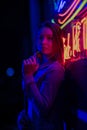 Creative sexual portrait of a girl in neon lighting with glasses, night party, dancing, game business, striptease