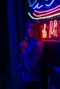 Creative sexual portrait of a girl in neon lighting with glasses, night party, dancing, game business, striptease