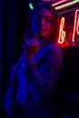 Creative sexual portrait of a girl in neon lighting with glasses, night party, dancing, game business, striptease