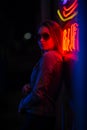 Creative sexual portrait of a girl in neon lighting with glasses, night party, dancing, game business, striptease