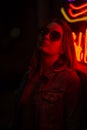 Creative sexual portrait of a girl in neon red glasses, night party, dancing, game business, striptease. Vertical photo