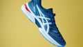 Creative shot of Asics Gel Nimbus running shoes on yellow background