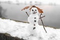 Creative snowman granny or grandpa stone eyes and buttons with sticknear river Royalty Free Stock Photo
