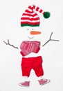 Creative snowman shape made of Santa elf`s hat and different items on white background, flat lay