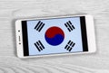 Creative South Korean Flag Consisting of a Smartphone over a Wooden Background