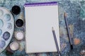 Creative space. The working space of the artist on the shabby table: paint gouache, notebook, pencils Royalty Free Stock Photo